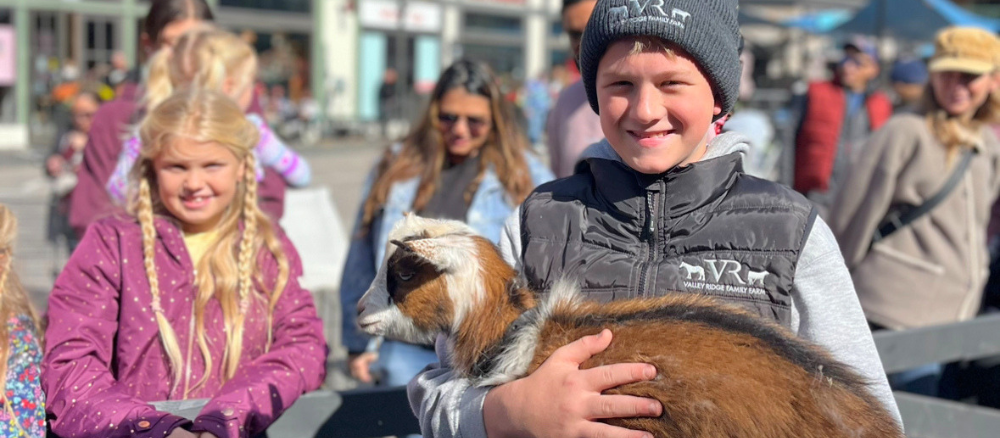 Children enjoy the Barnyard Bonanza petting zoo with baby goats at Blue Mountain Village