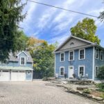 Blue-and-white Thornbury waterfront home at 40 Alice Street E with detached two-bay garage and brick courtyard